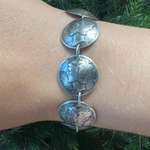 U.S. Mercury Dime Silver Coin Bracelet on a wrist in front of a pine tree. - Mountainstruck Coin Jewelry
