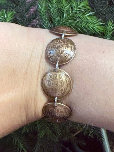 U.S. Wheat Penny Domed Coin Bracelet back on a wrist in front a pine tree. - Mountainstruck Coin Jewelry