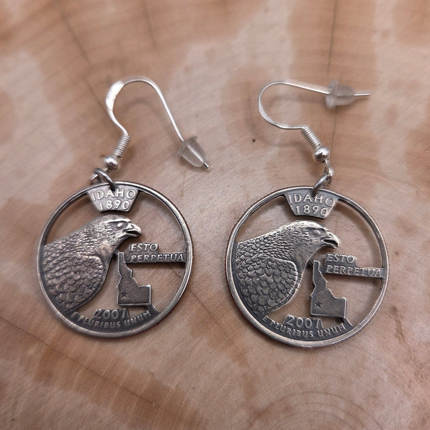 Idahome State Quarter Hand Cut Coin Earrings on a wood background. - Mountainstruck Coin Jewelry