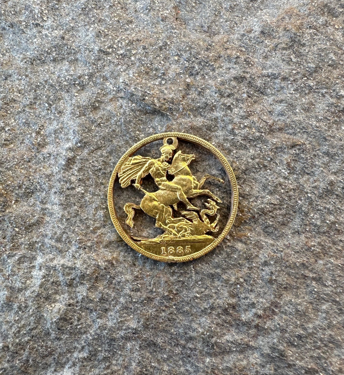 22k Solid Gold UK Gold Sovereign hand cut coin necklace on a grey rock background. - Mountainstruck Coin Jewelry