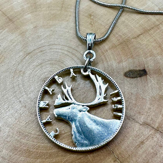 Caribou Canada Silver 25 Cent Hand Cut Coin Necklace on a light wood round. - Mountainstruck Coin Jewelry