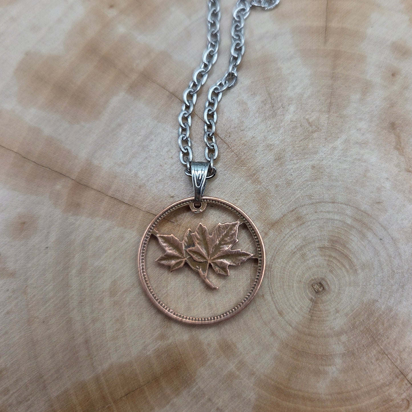 Canada Maple Leaf Penny Hand Cut Coin Necklace on a wood background. - Mountainstruck Coin Jewelry