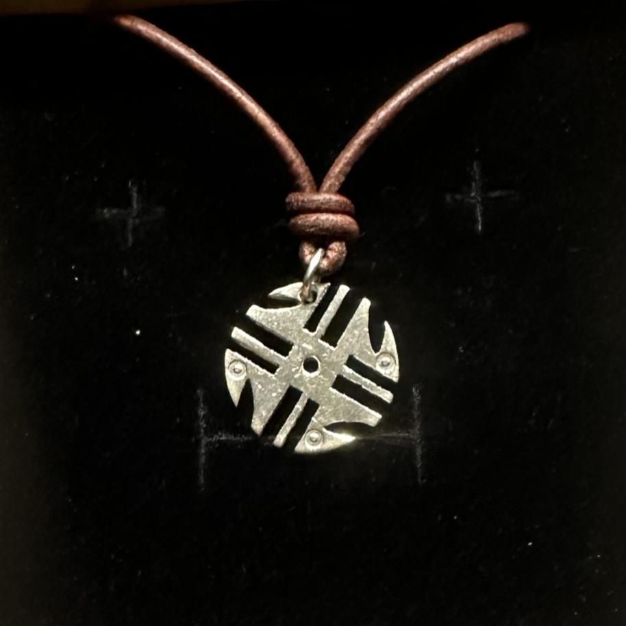 Columbia 200 Pesos Quimbaya Spindle Wheel Hand Cut Coin Necklace in a brown kraft box on a black velvet background. - Mountainstruck Coin Jewelry