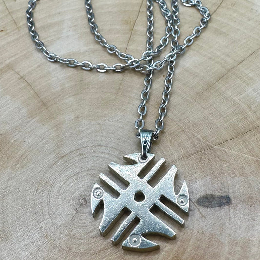 Columbia 200 Pesos Quimbaya Spindle Wheel Hand Cut Coin Necklace with a stainless chain on a light wood round. - Mountainstruck Coin Jewelry