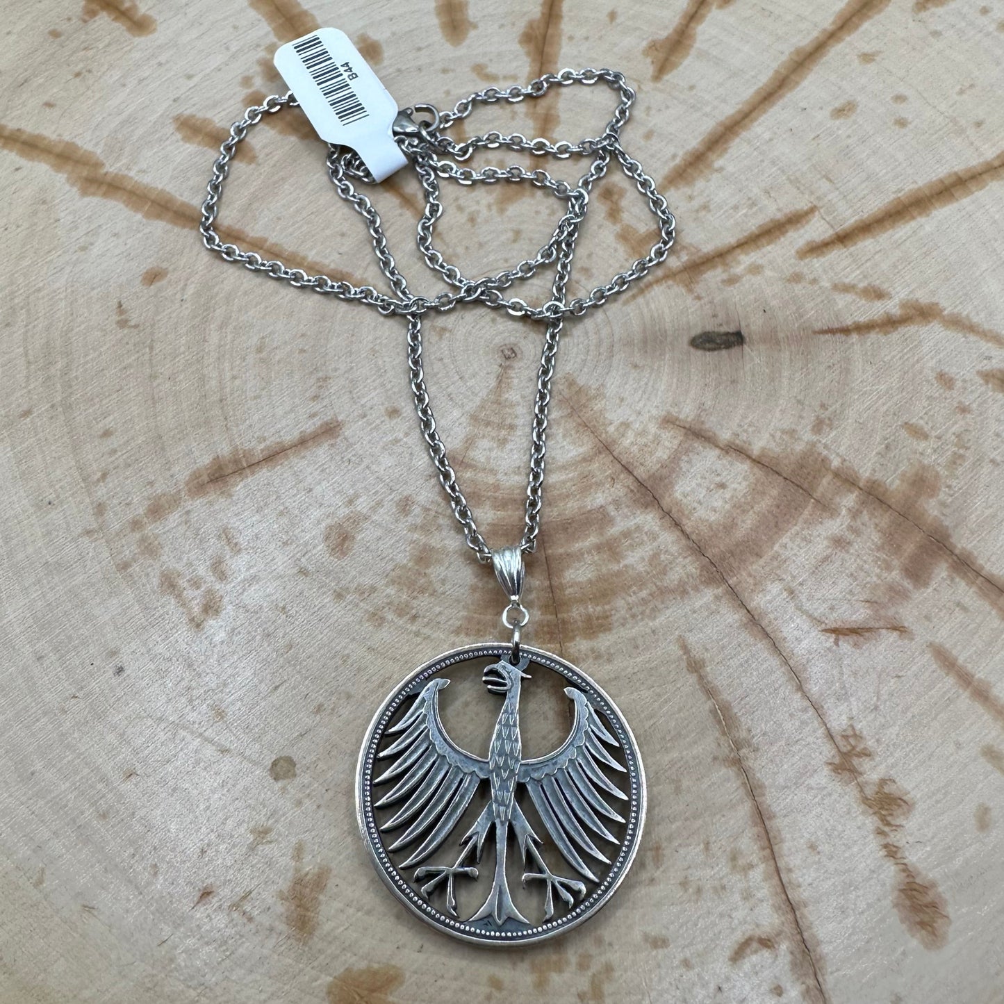 Germany Silver Eagle 5 Mark Hand Cut Coin Necklace on wood background. - Mountainstruck Coin Jewelry