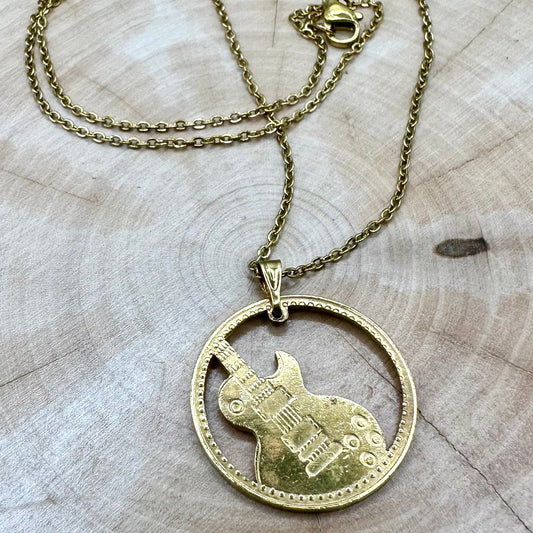 Guitar Hand Cut Token Necklace on a light wood round. - Mountainstruck Coin Jewelry
