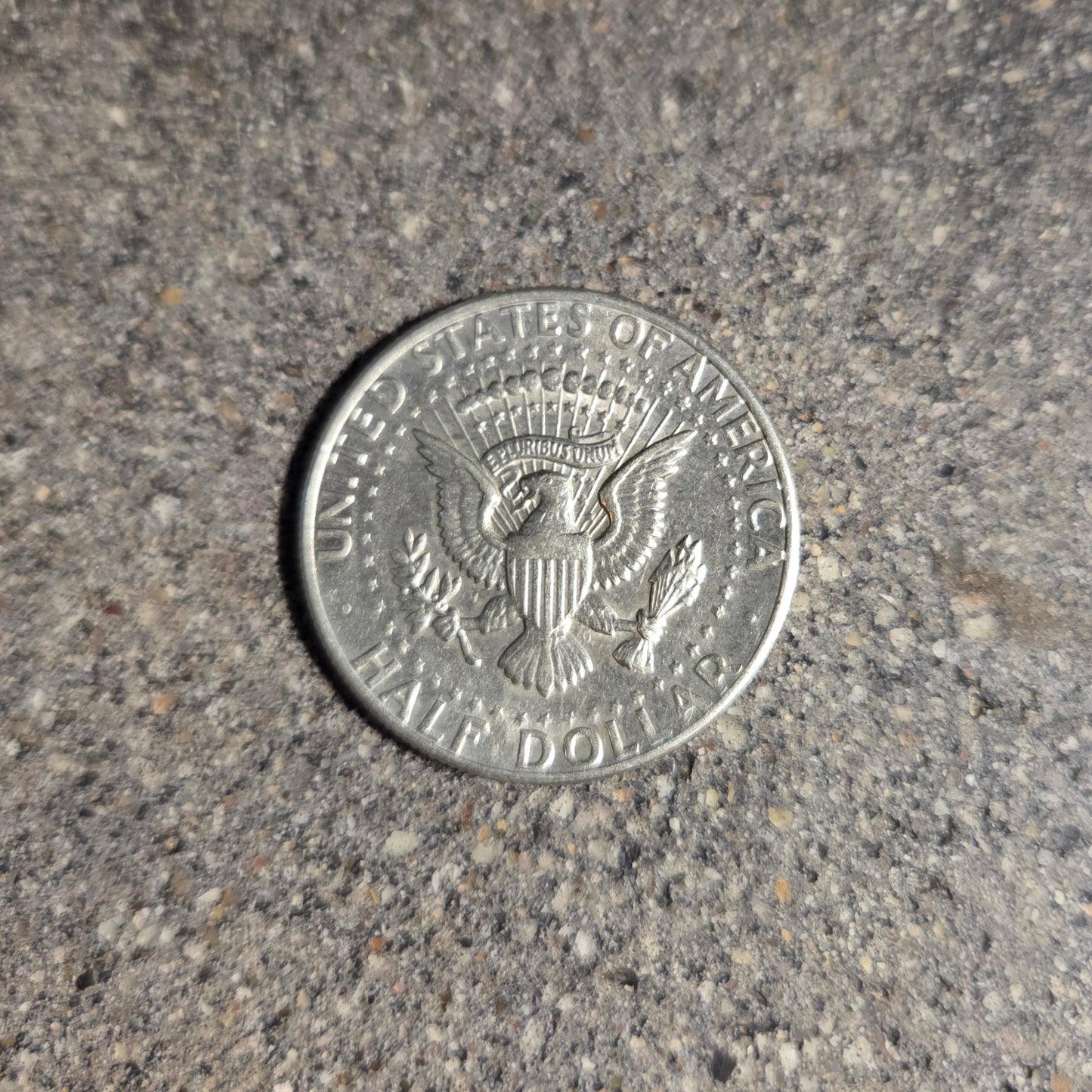 U.S. Half Dollar coin back on a concrete background. - Mountainstruck Coin Jewelry