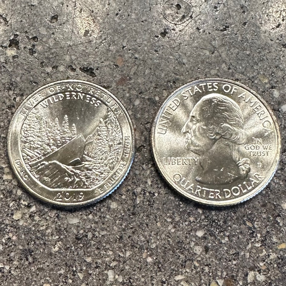 Idaho "River of No Return" coin on a concrete background. Back side of the coin on the left and front side of the coin on the right side of the picture. - Mountainstruck Coin Jewelry