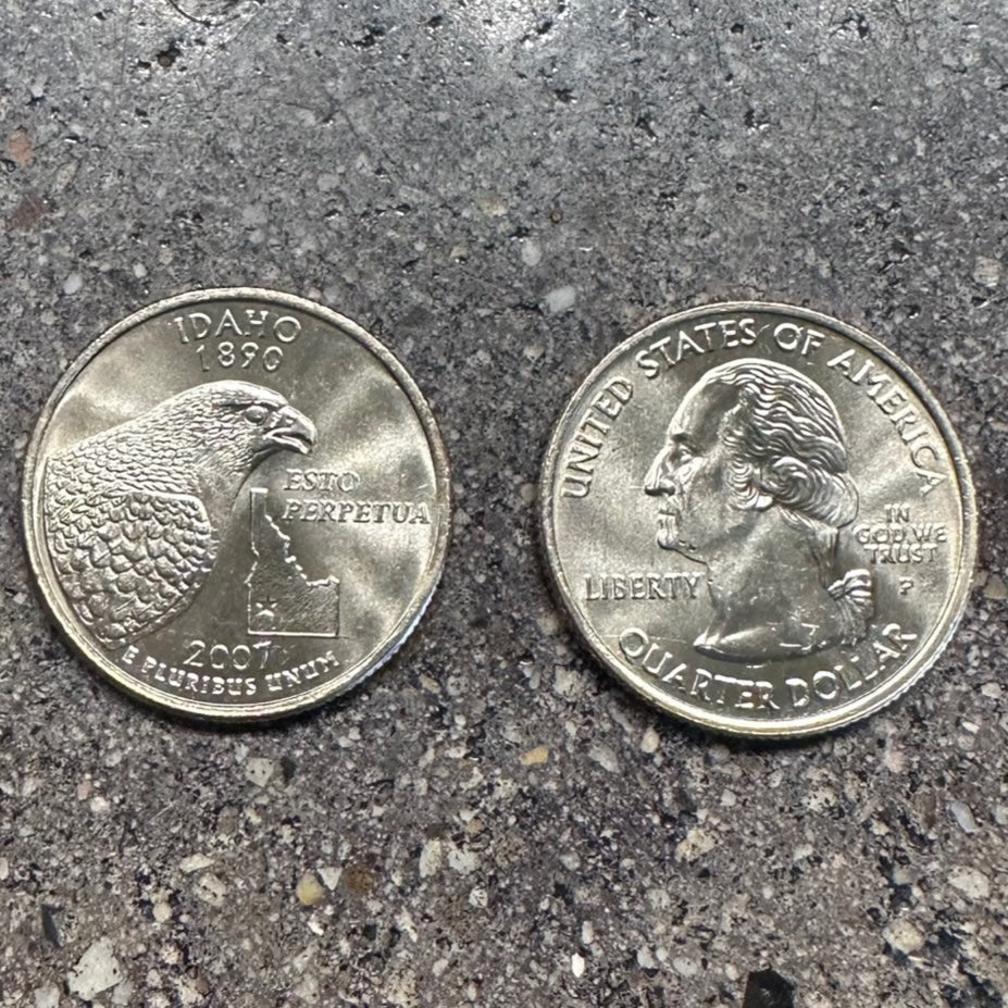 Idaho State Quarter on a concrete background. Back side of coin on the left of the image and front side of the coin on the right side. - Mountainstruck Coin Jewelry