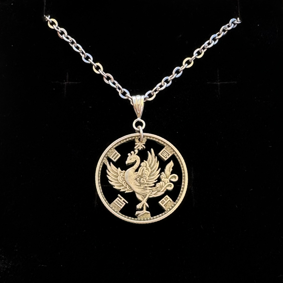 Japan Phoenix 100 Yen Silver Hand Cut Coin Necklace on a black velvet background. - Mountainstruck Coin Jewelry