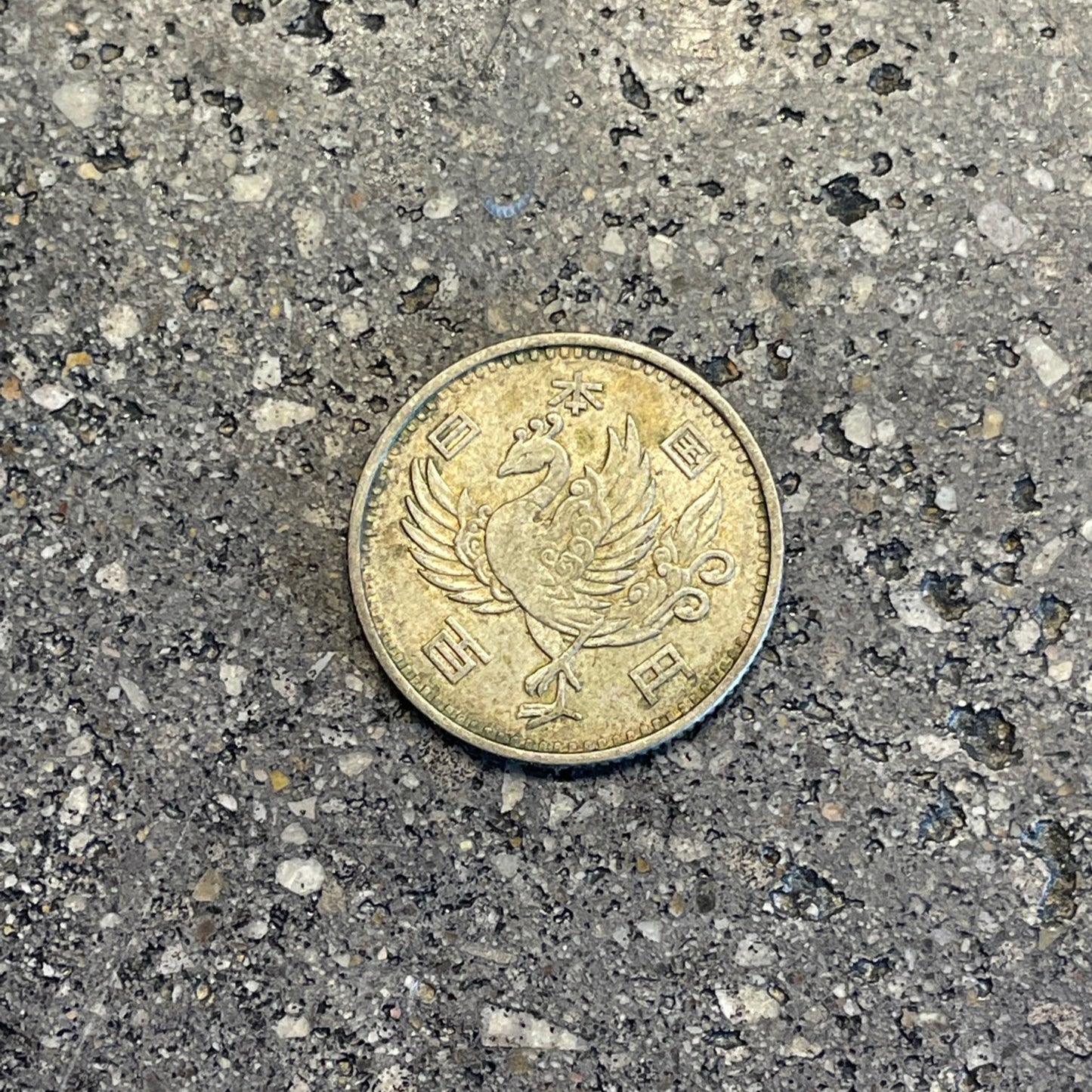 Phoenix Japan 100 Yen Silver Coin front on a concrete background. - Mountainstruck Coin Jewelry