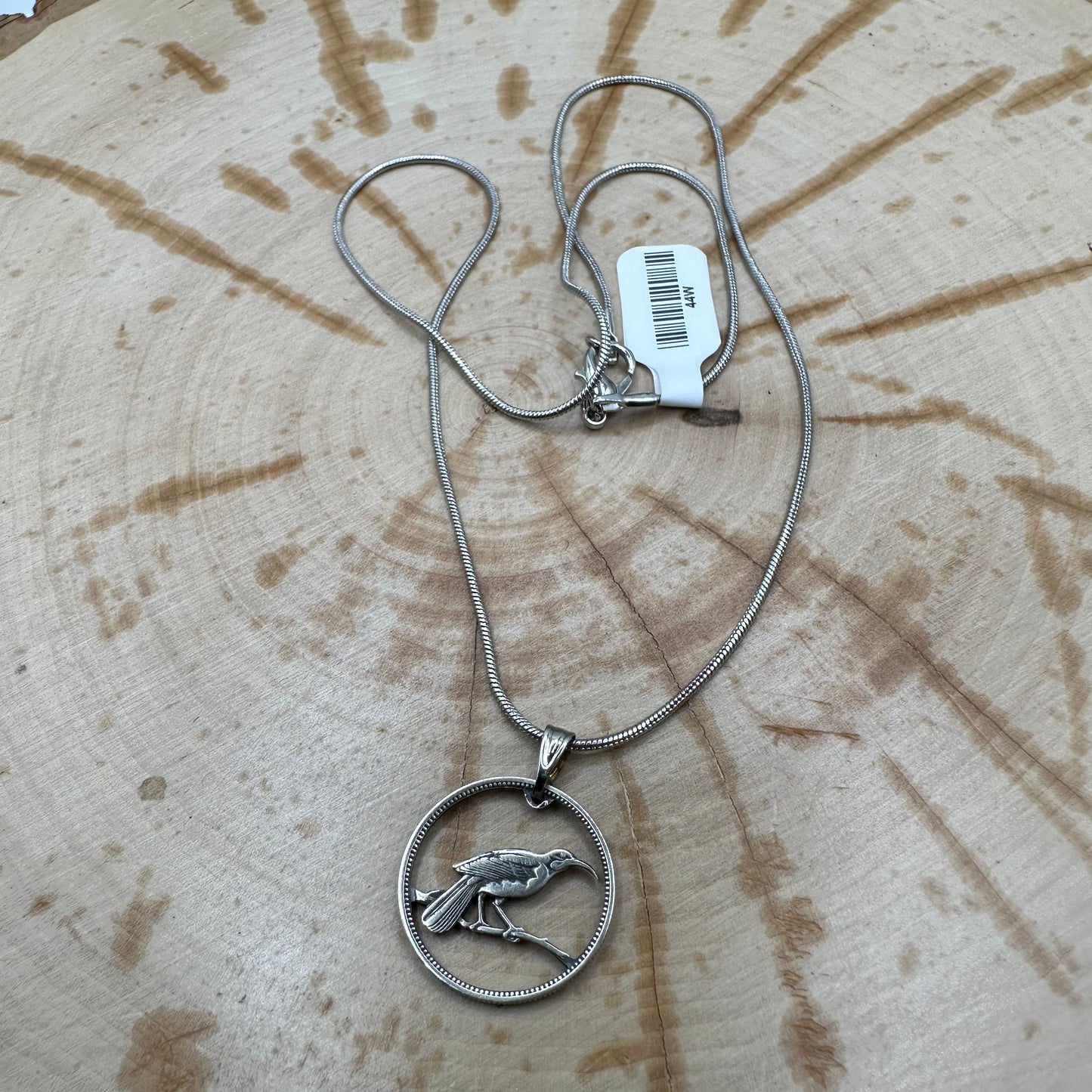 Huia Bird Silver New Zealand 6 Pence Hand Cut Coin Necklace on a black velvet background. - Mountainstruck Coin Jewelry