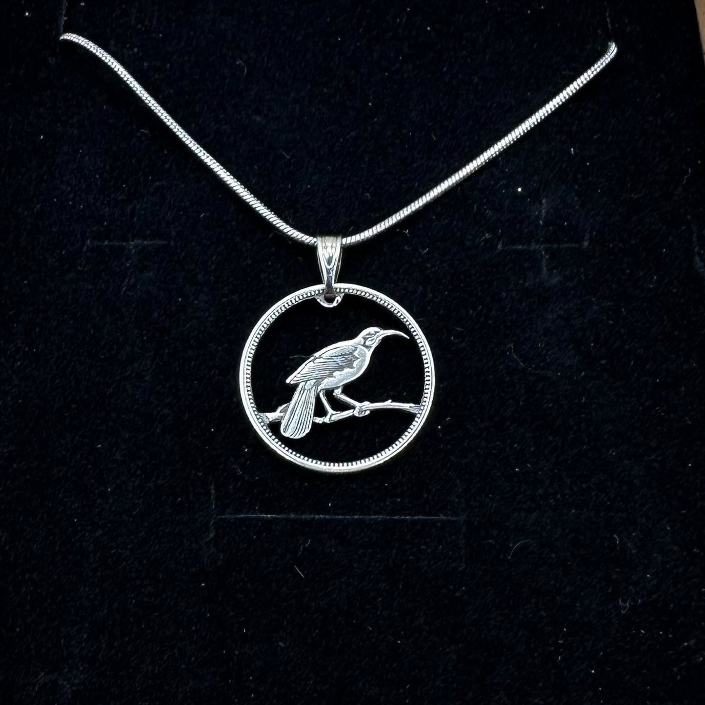Huia Bird Silver New Zealand 6 Pence Hand Cut Coin Necklace on a black velvet background. - Mountainstruck Coin Jewelry