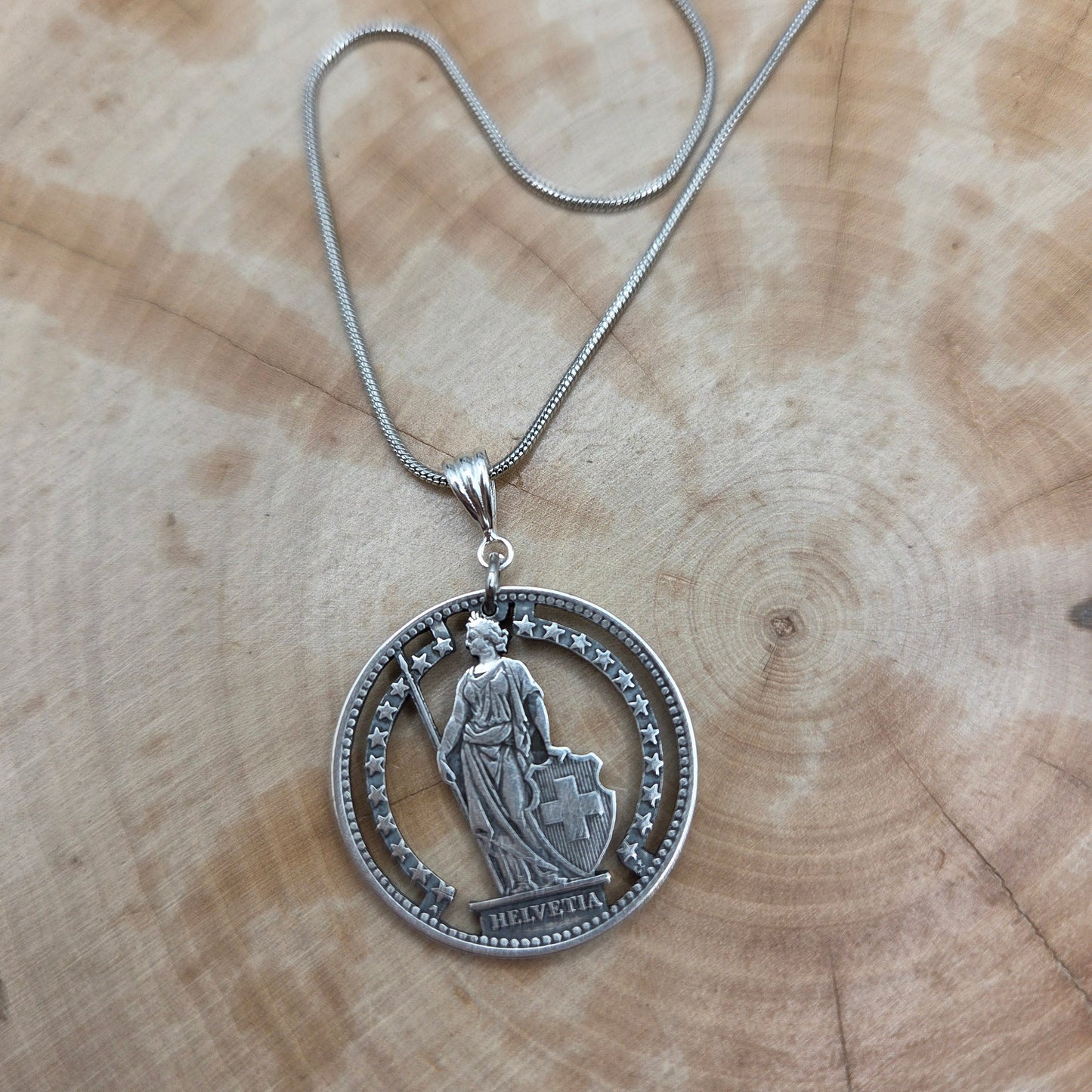 Swiss Lady 1 Franc Silver Hand Cut Coin Necklace on a wood background. - Mountainstruck Coin Jewelry
