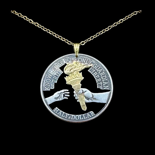 U.S. 2026 Half Dollar Hand Cut Coin Necklace (reverse) 24k Gold Plated Torch with a gold plated chain on a black velvet background. - Mountainstruck Coin Jewelry