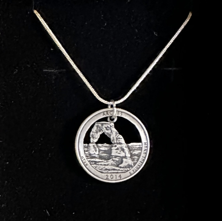 U.S. Arches National Park Coin Necklace on a black velvet background. - Mountainstruck Coin Jewelry