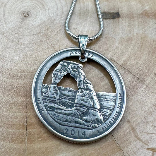 U.S. Arches National Park Hand Cut Coin Necklace with snake chain on a light wood round. - Mountainstruck Coin Jewelry