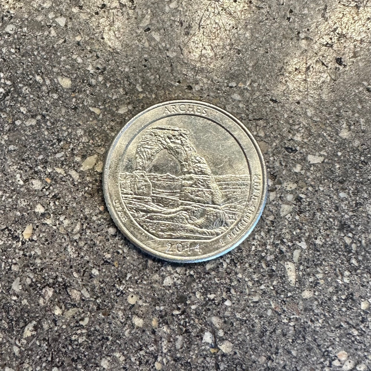 U.S. Arches National Park Coin back on a concrete background. - Mountainstruck Coin Jewelry
