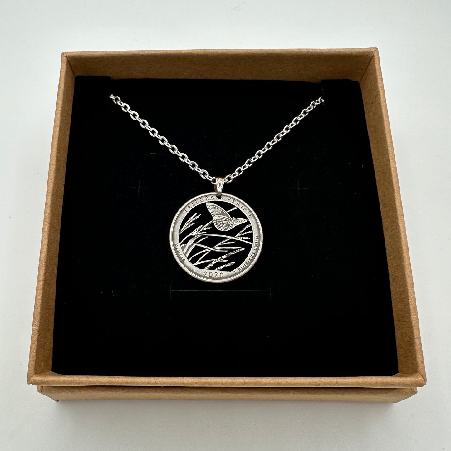 U.S. Butterfly Tallgrass Prairie Quarter Hand Cut Coin Necklace
in a brown kraft box on a black velvet background - Mountainstruck Coin Jewelry