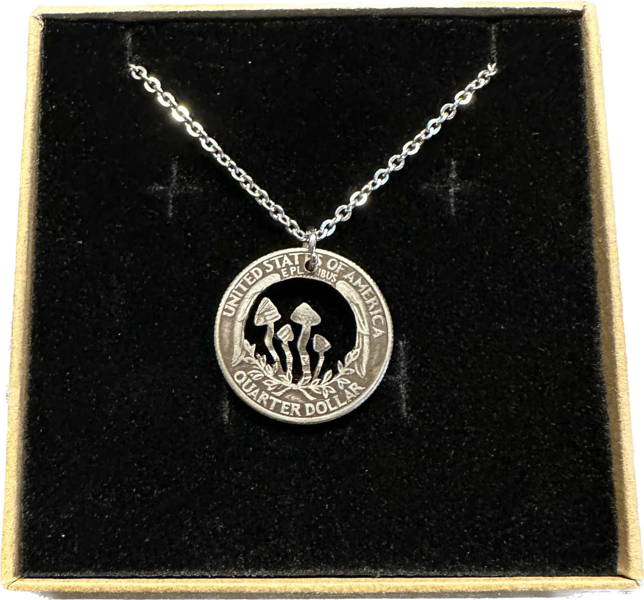 U.S. Custom Mushroom Quarter Hand Cut Coin Necklace with stainless chain in a brown kraft box on a black velvet background.- Mountainstruck Coin Jewelry