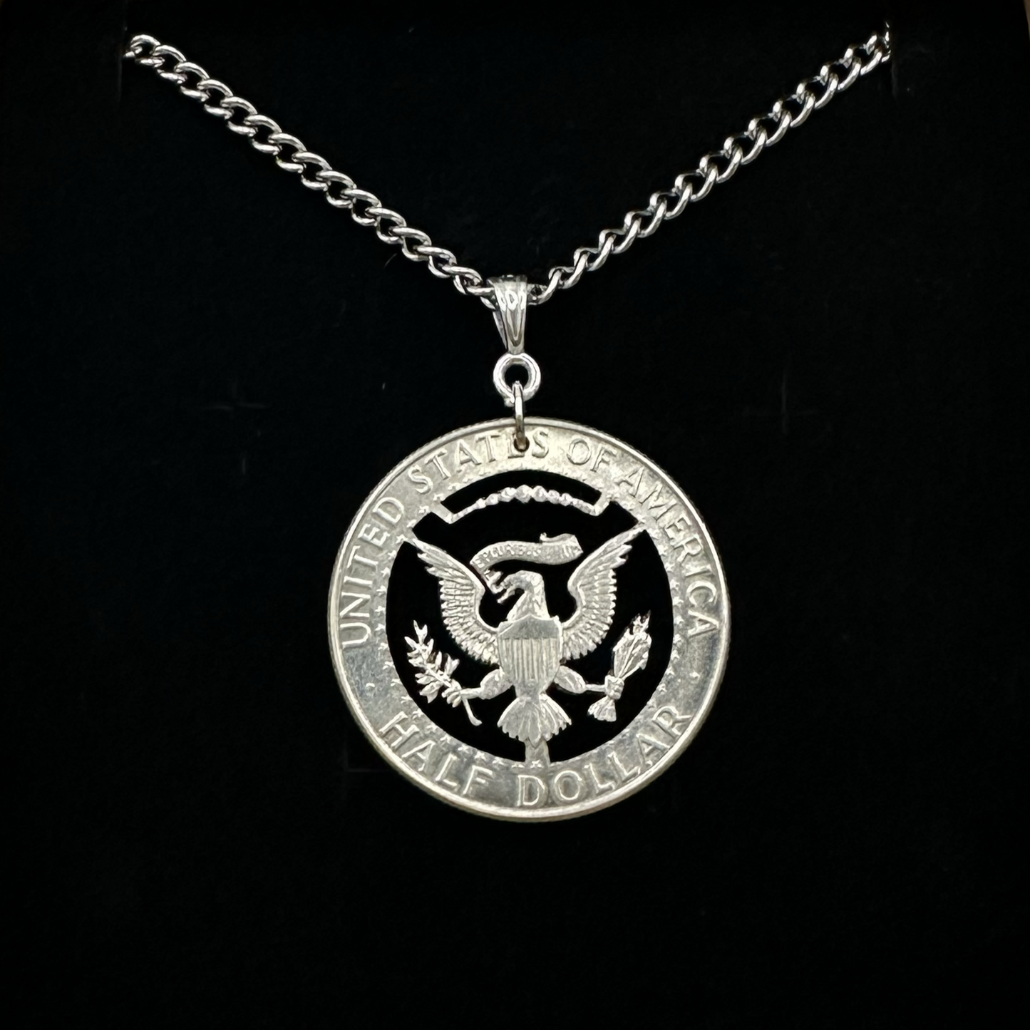 U.S. Eagle Half Dollar Hand Cut Silver Coin Necklace on a black velvet background. - Mountainstruck Coin Jewelry