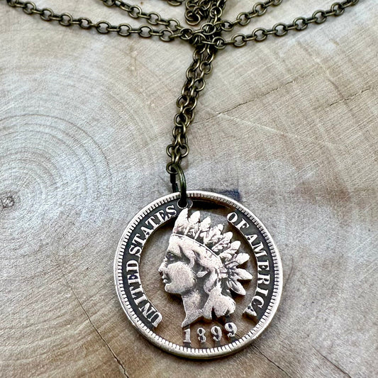 U.S. Indian Head Penny Hand Cut Coin Necklace with bronze chain on light a wood background. - Mountainstruck Coin Jewelry