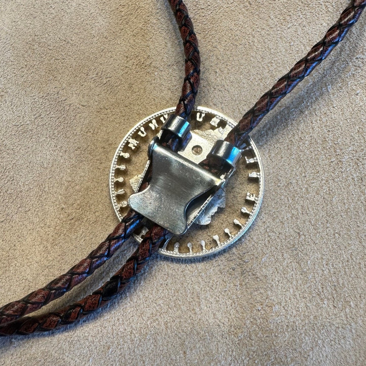 U.S. Morgan Hand Cut Silver Dollar Coin Bolo Tie (front) close up of back clasp on light cloth background. - Mountainstruck Coin Jewelry