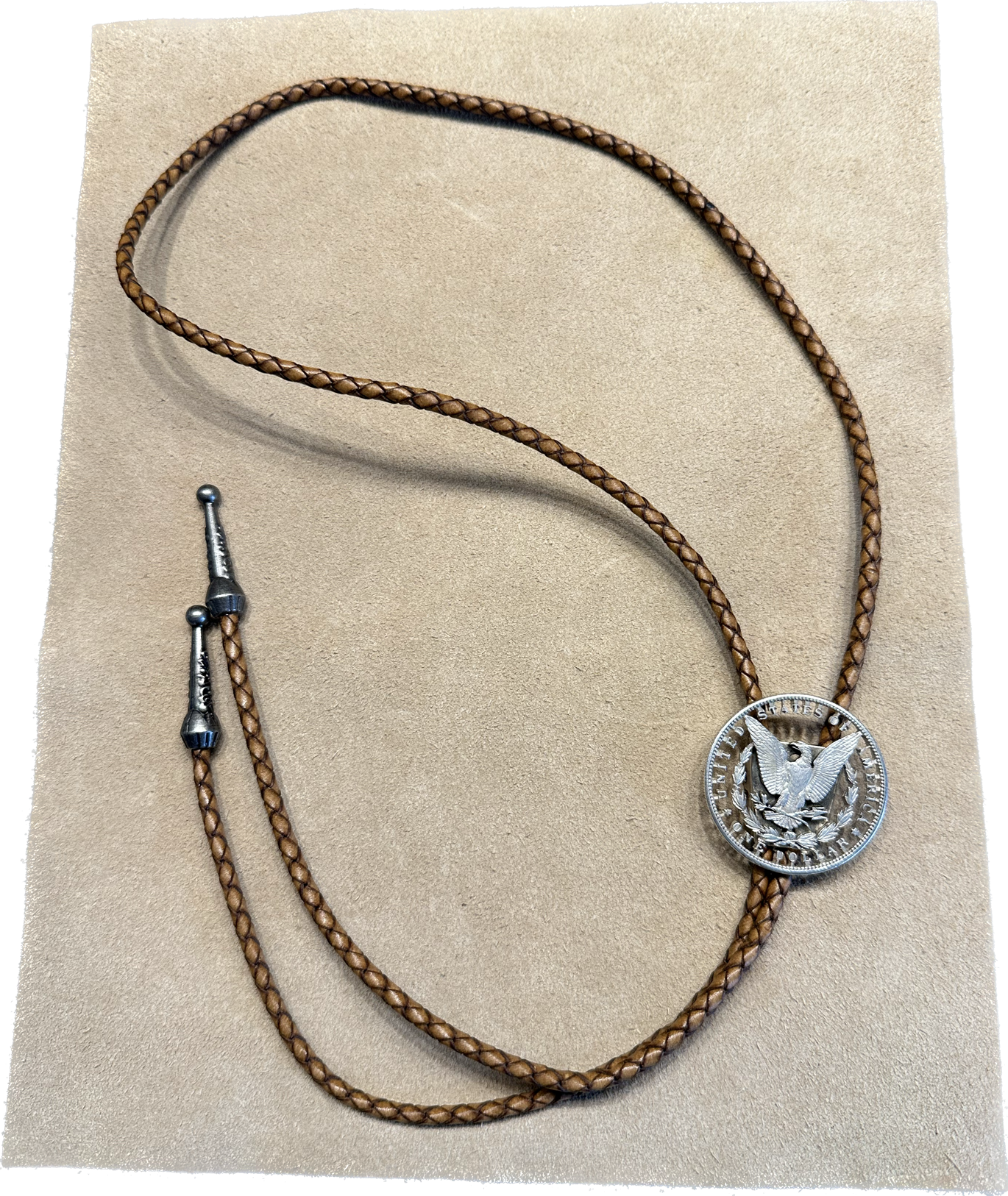 U.S. Morgan Hand Cut Silver Dollar Coin Bolo Tie (reverse) on light cloth background. - Mountainstruck Coin Jewelry