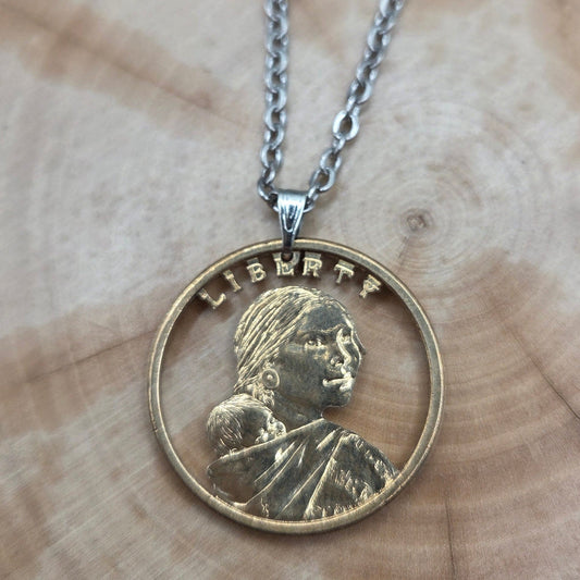U.S. Sacagawea 1 Dollar Hand Cut Coin Necklace with stainless chain on a wood background. - Mountainstruck Coin Jewelry