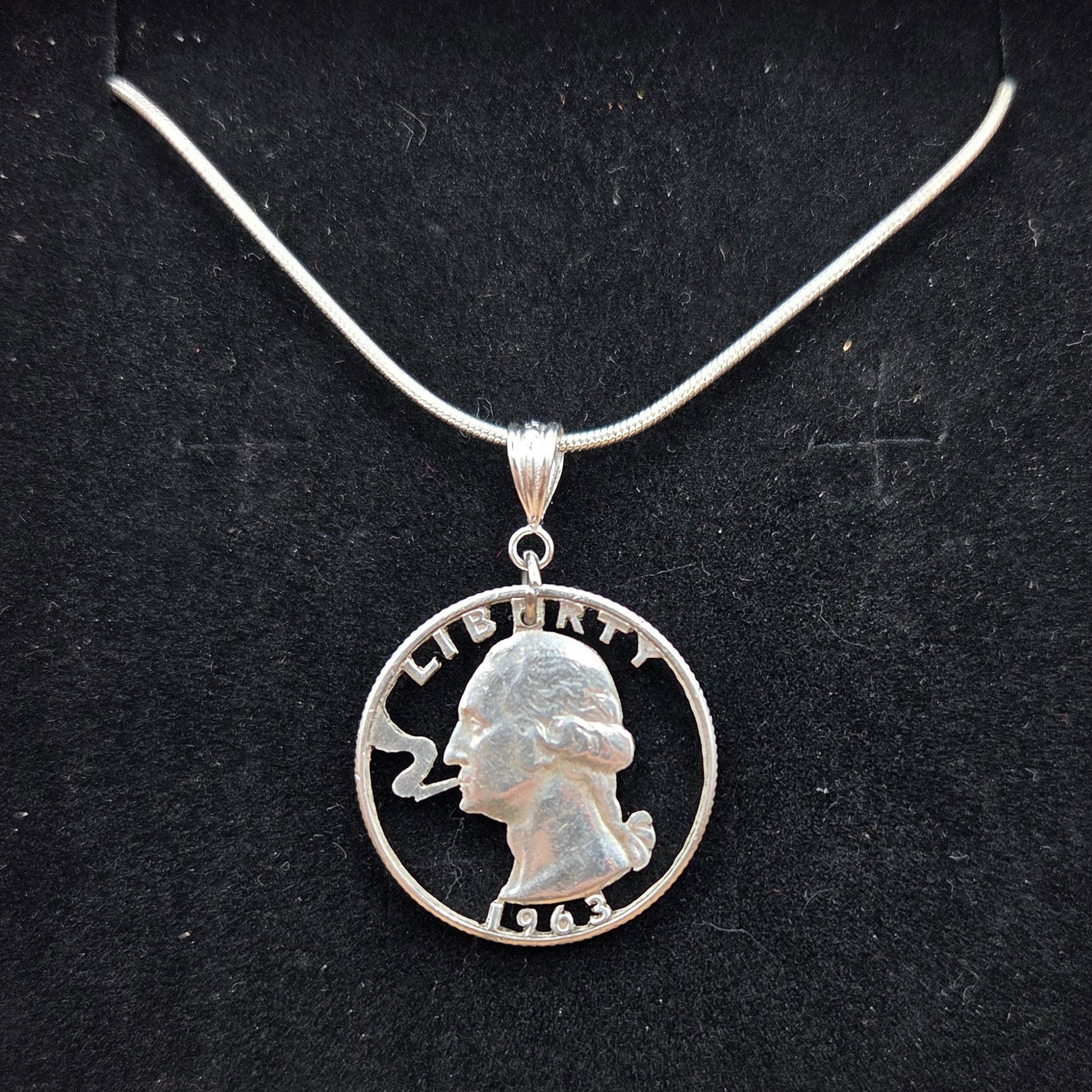 U.S. Smoking GW Silver Quarter Hand Cut Coin Necklace with a snake chain on a black velvet background. - Mountainstruck Coin Jewelry