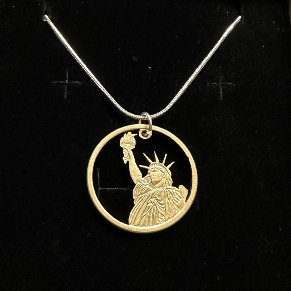 U.S. Statue of Liberty Dollar Hand Cut Coin Necklace with a snake chain in a brown kraft box on a black velvet background. - Mountainstruck Coin Jewelry