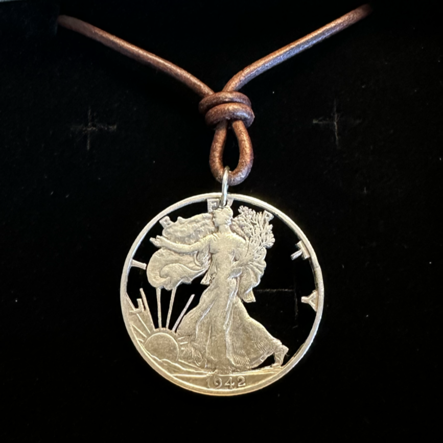 U.S. Walking Liberty Silver Hand Cut Coin Necklace (Lady Liberty) with a leather cord in a brown kraft box on a black velvet background. - Mountainstruck Coin Jewelry