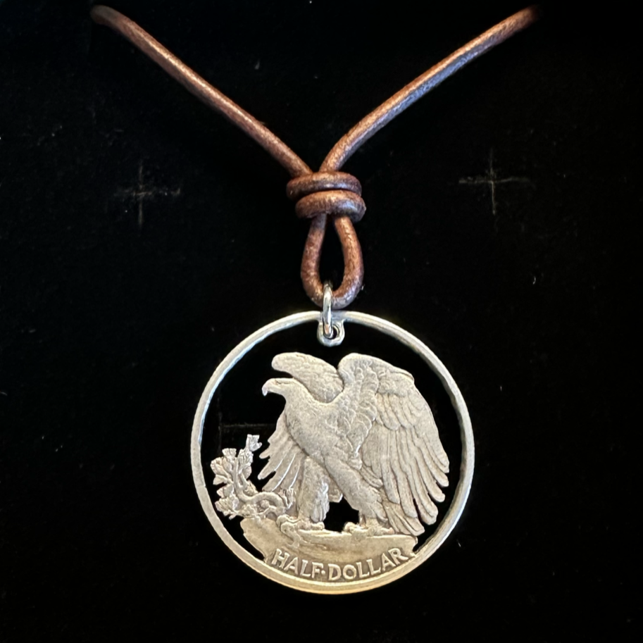 U.S. Walking Liberty Silver Hand Cut Coin Necklace (Eagle) with a leather cord in a brown kraft box on a black velvet background. - Mountainstruck Coin Jewelry