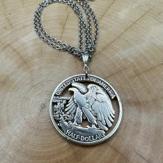 U.S. Walking Liberty Silver Hand Cut Coin Necklace (Eagle) with a snake chain on a light wood background. - Mountainstruck Coin Jewelry