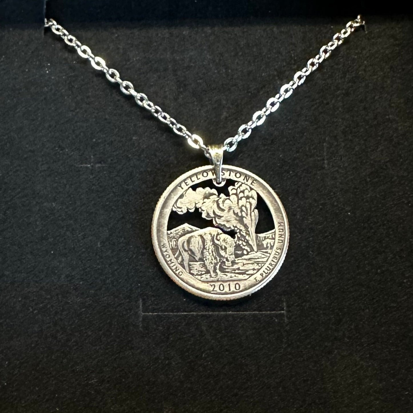 U.S. Yellowstone National Park Quarter Hand Cut Coin Necklace on a black velvet background. - Mountainstruck Coin Jewelry