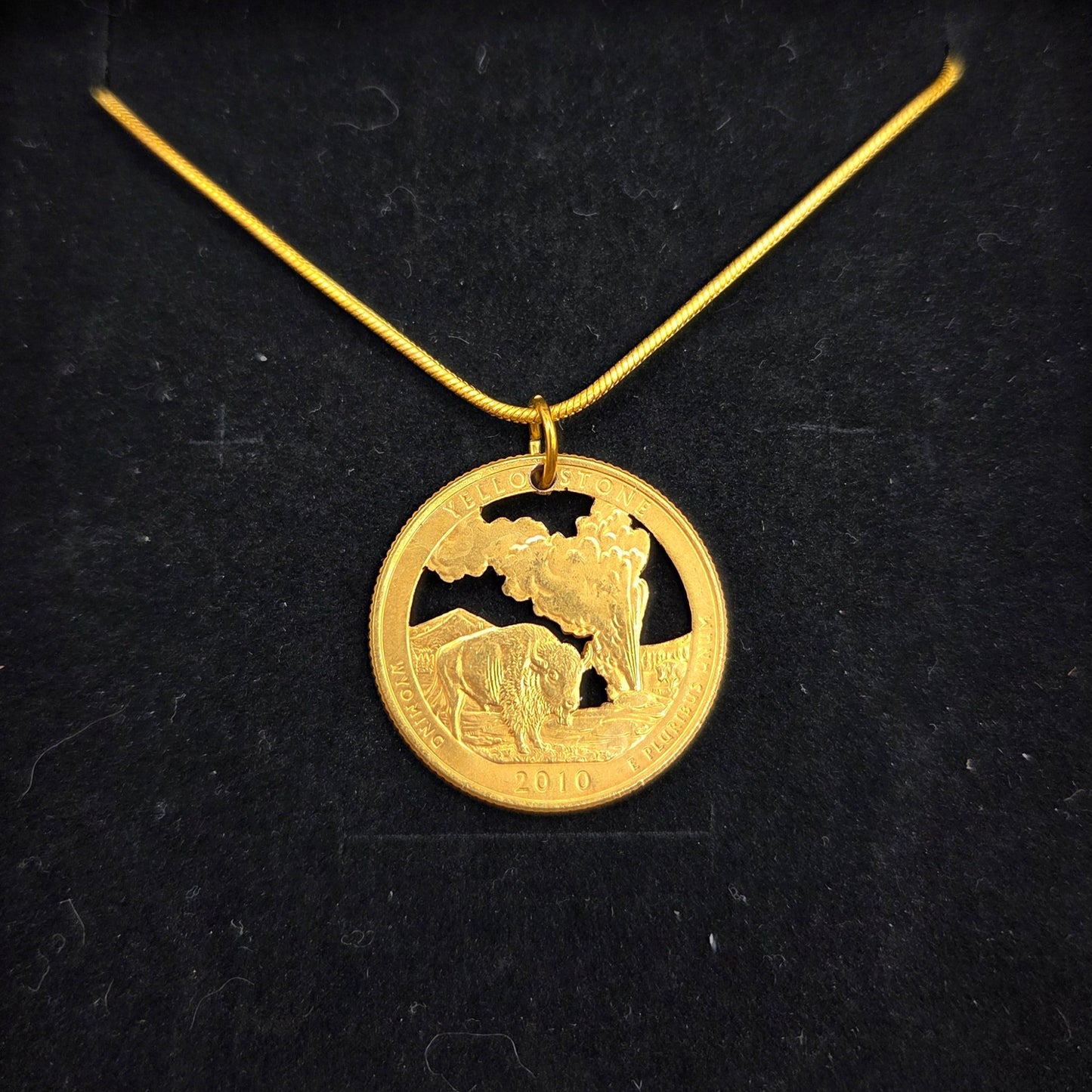 U.S. Yellowstone National Park Quarter Hand Cut Coin Necklace 24k gold plate on a black velvet background. - Mountainstruck Coin Jewelry