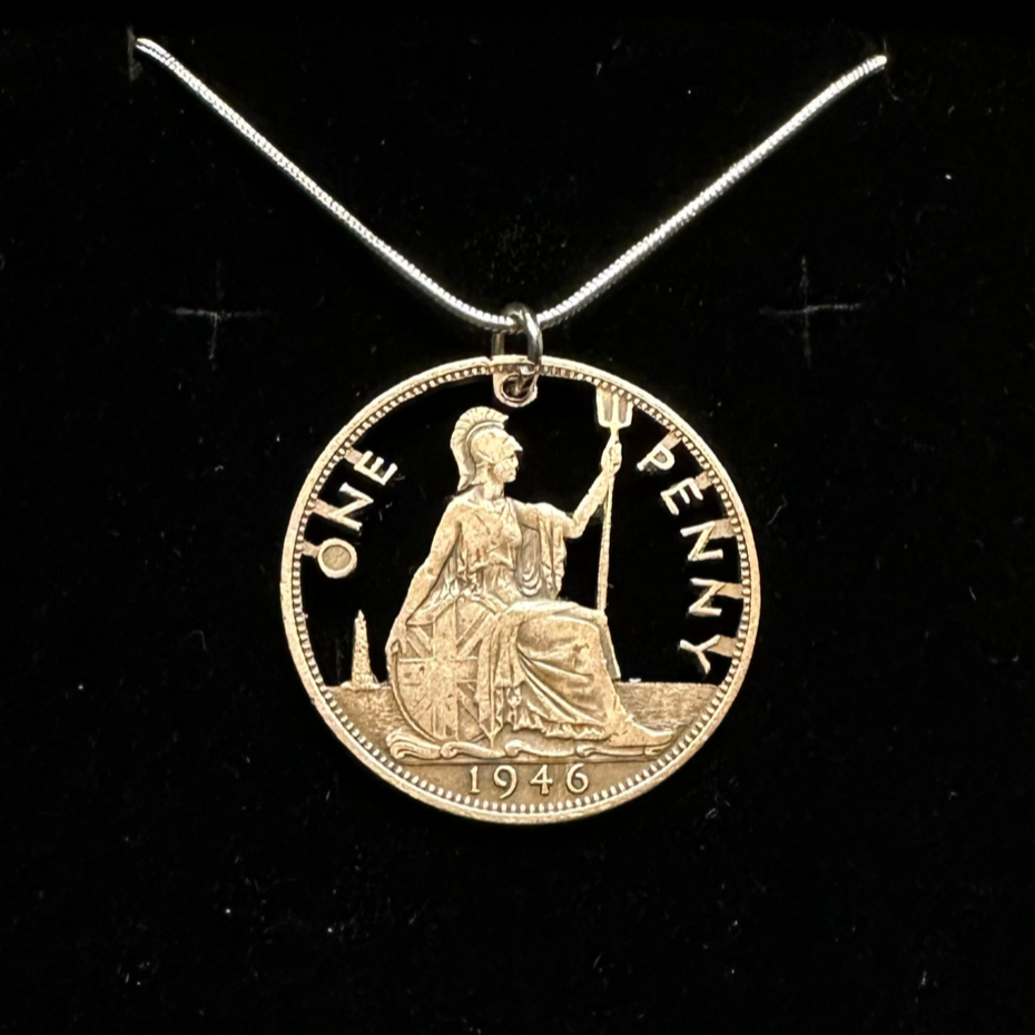 UK One Penny Hand Cut Coin Necklace with a snake chain in a brown kraft box on a black velvet background. - Mountainstruck Coin Jewelry