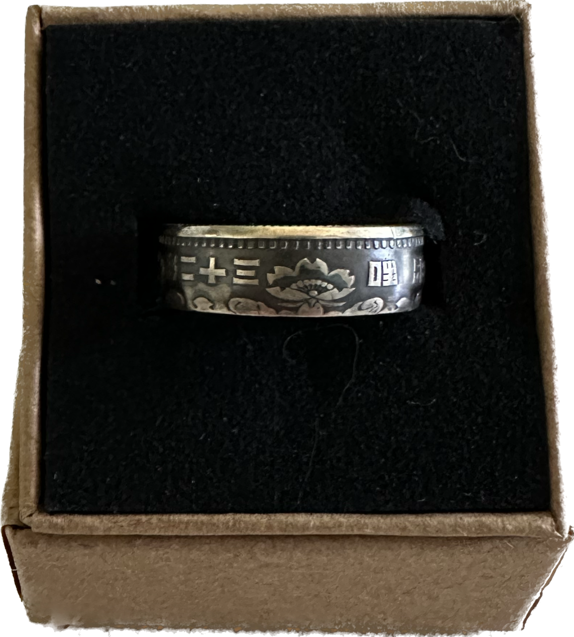 Japan 100 Yen Silver Coin Ring in a brown kraft box on a black velvet background. - Mountainstruck Coin Jewelry