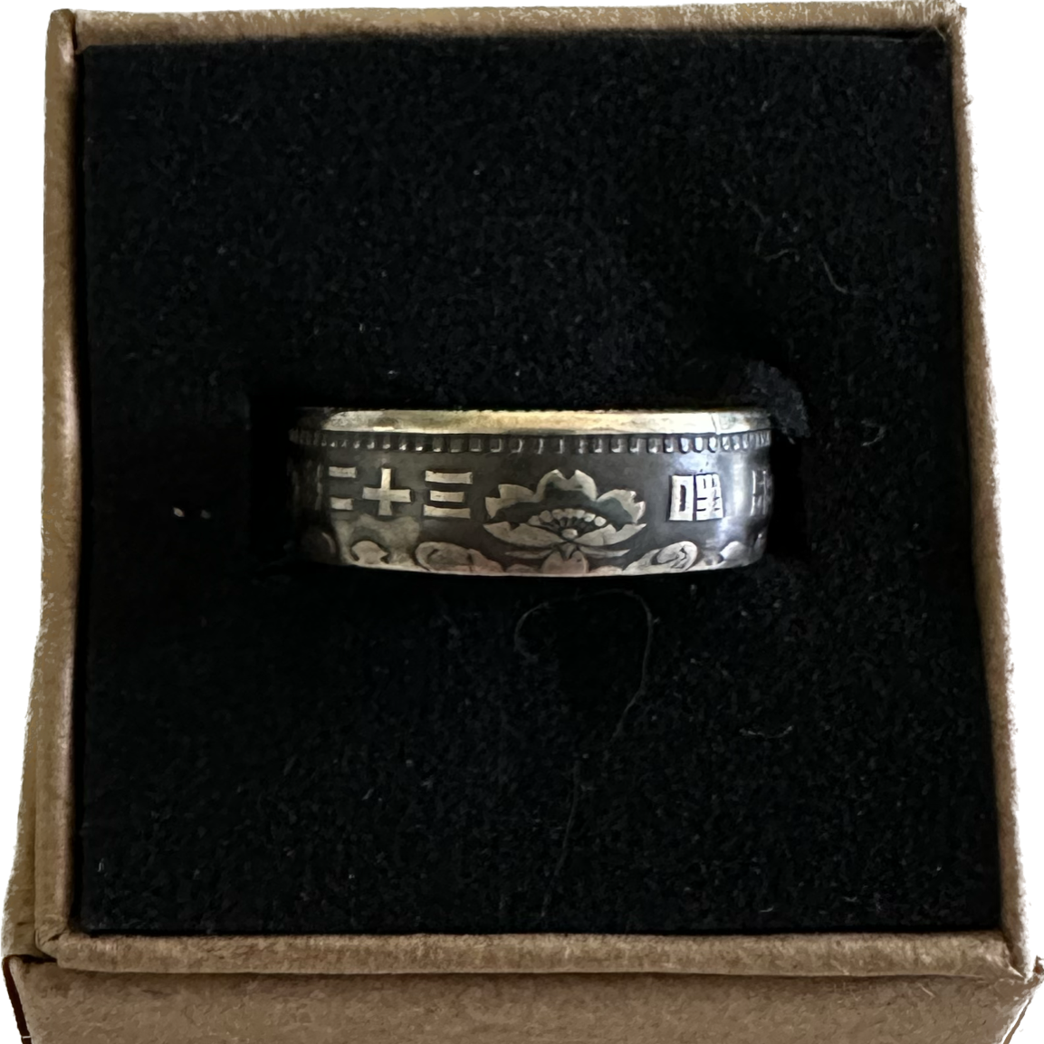 Japan 100 Yen Silver Coin Ring in a brown kraft box on a black velvet background. - Mountainstruck Coin Jewelry