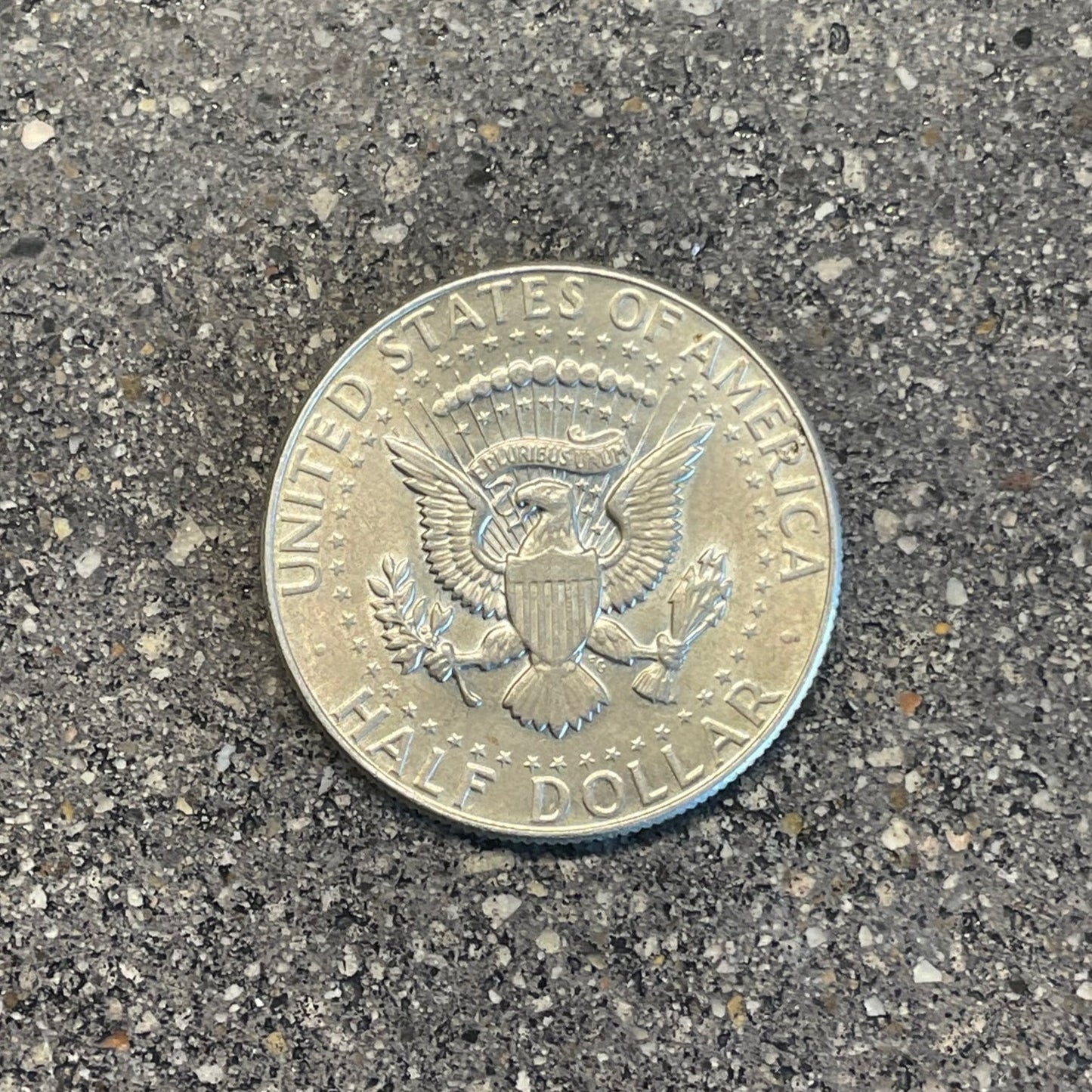 JFK Silver Half Dollar Coin back on a concrete background. - Mountainstruck Coin Jewelry