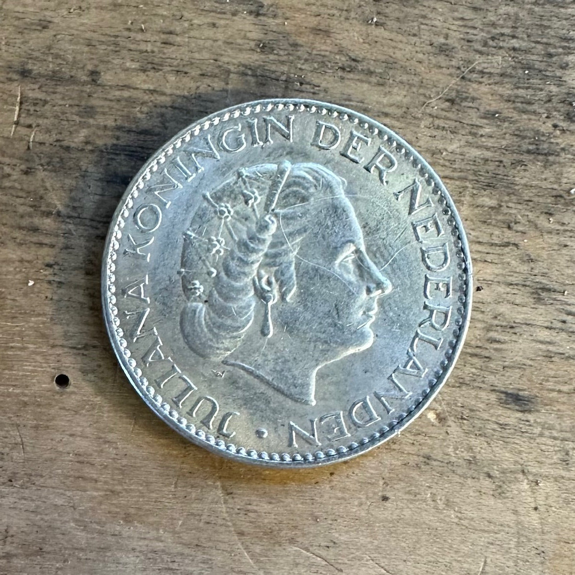 Netherlands 1 Gulden Silver Coin front on wooden surface. - Mountainstruck Coin Jewelry