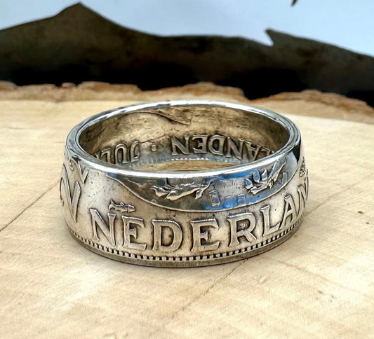Netherlands 2.5 Gulden Silver Coin Ring on a light wood round with a metal mountain background. - Mountainstruck Coin Jewelry
