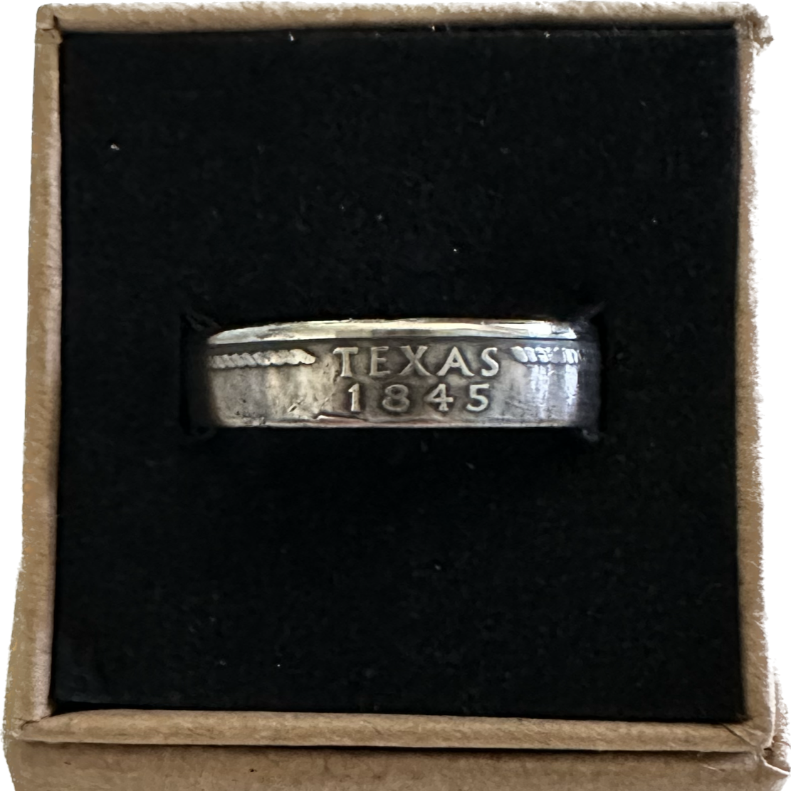 U.S. State Quarter Coin Ring featuring Texas in a brown kraft box on a black velvet background. - Mountainstruck Coin Jewelry