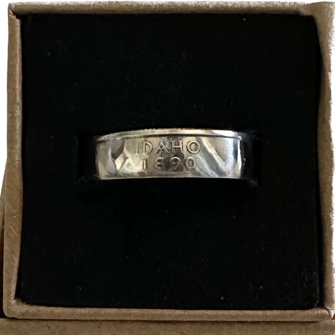 U.S. State Quarter Coin Ring featuring Idaho in a brown kraft box on a black velvet background. - Mountainstruck Coin Jewelry