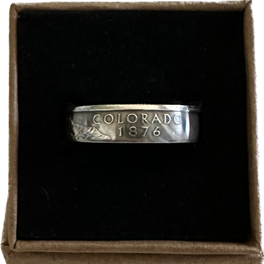 U.S. State Quarter Silver Coin Ring featuring Colorado in a brown kraft box on a black velvet background. - Mountainstruck Coin Jewelry