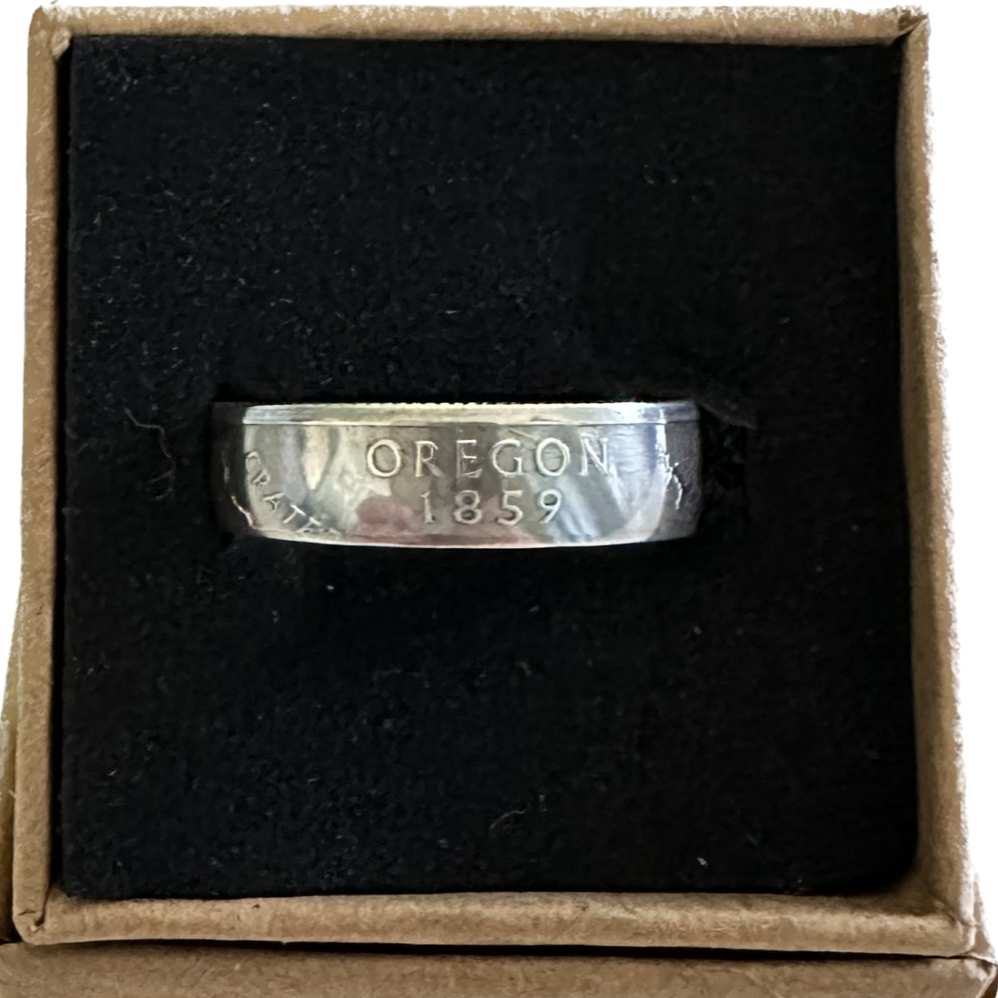 U.S. State Quarter Silver Coin Ring featuring Oregon in a brown kraft box on a black velvet background. - Mountainstruck Coin Jewelry