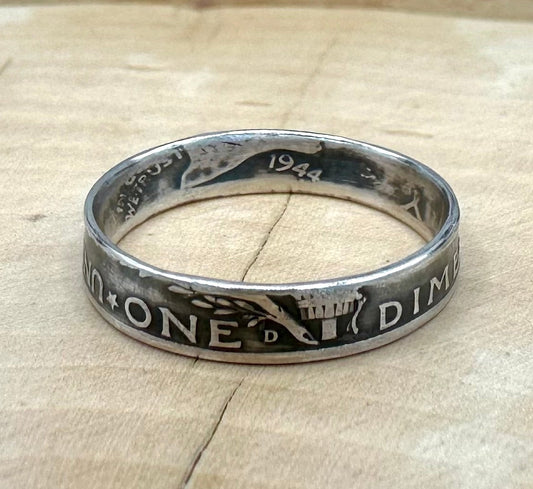 U.S. Mercury Dime Silver Coin Ring on a light wood round with metal mountains in the background. - Mountainstruck Coin Jewelry