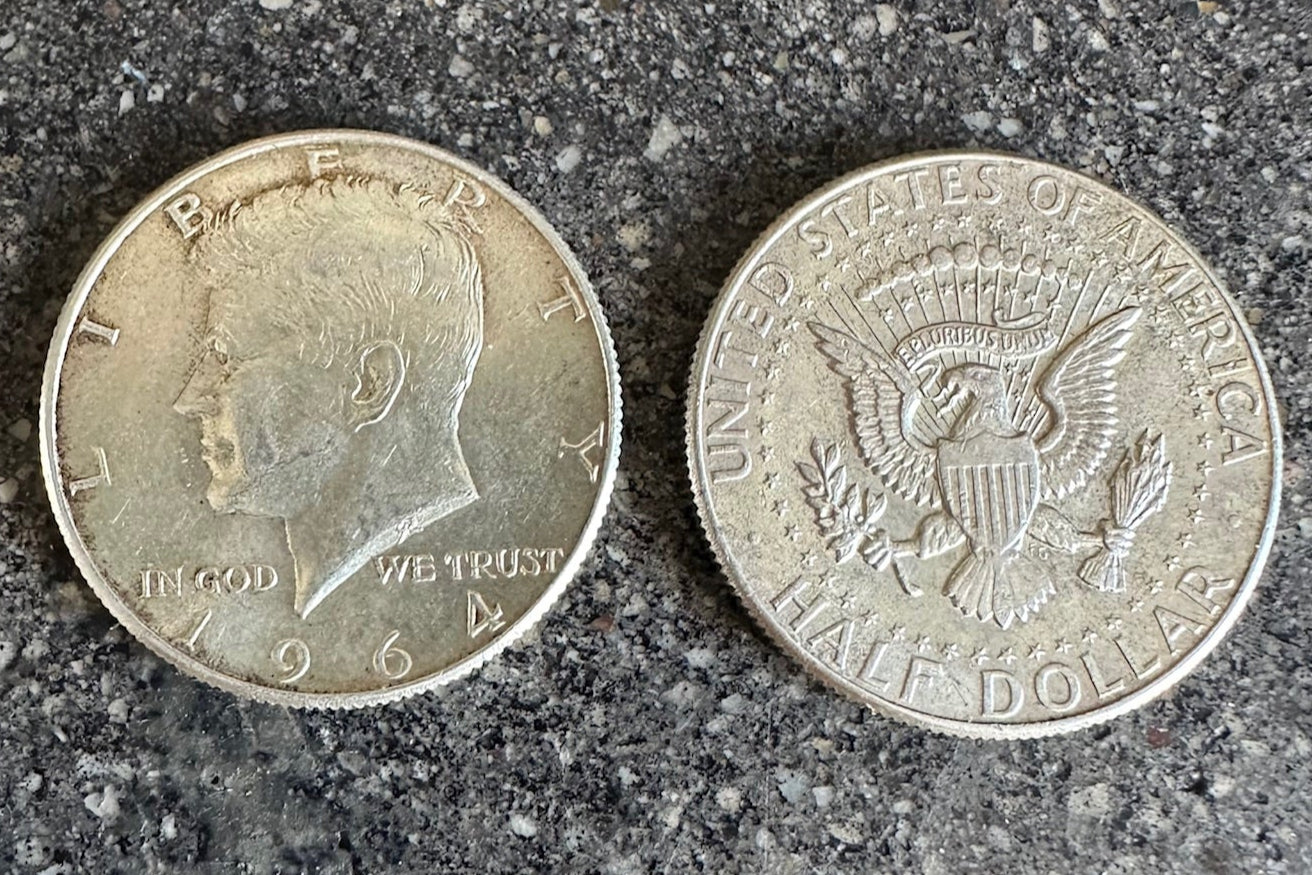U.S. JFK 1964 Half Dollar Silver Coins on a dark grey concrete background- Mountainstruck Coin Jewelry