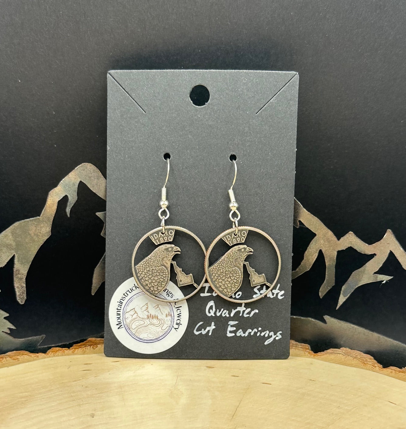 Idahome State Quarter Hand Cut Coin Earrings on a black earring backing.
