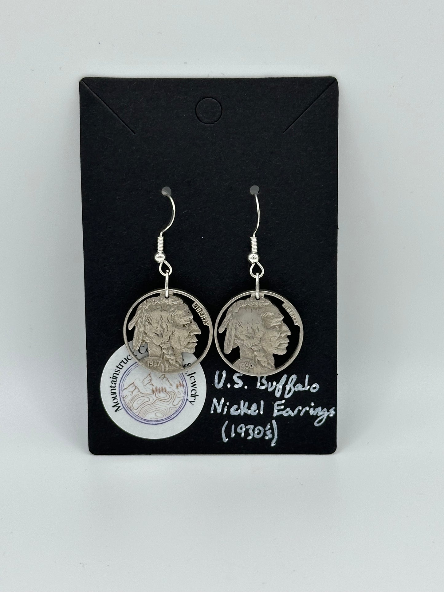 Native Nickel Cut Coin Earrings on black background with round Mountainstruck Coin Ring & Jewelry sticker in bottom left corner.